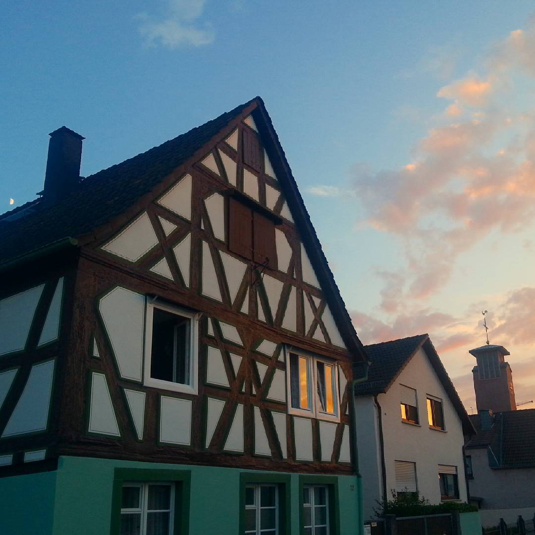 Kunstvolles Fachwerk gibt es nicht nur im Seligenstädter Stadtkern. Auch in Klein-Welzheim findet man beispielsweise dieses schöne Fachwerkhaus. Im Hintergrund sieht man den Kirchturm, den Mond und einen leuchtenden Abendhimmel