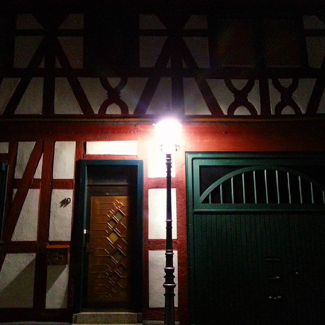 Eine Straßenlaterne in der Altstadt vor einem stimmungsvoll angeleuchteten Fachwerkhaus